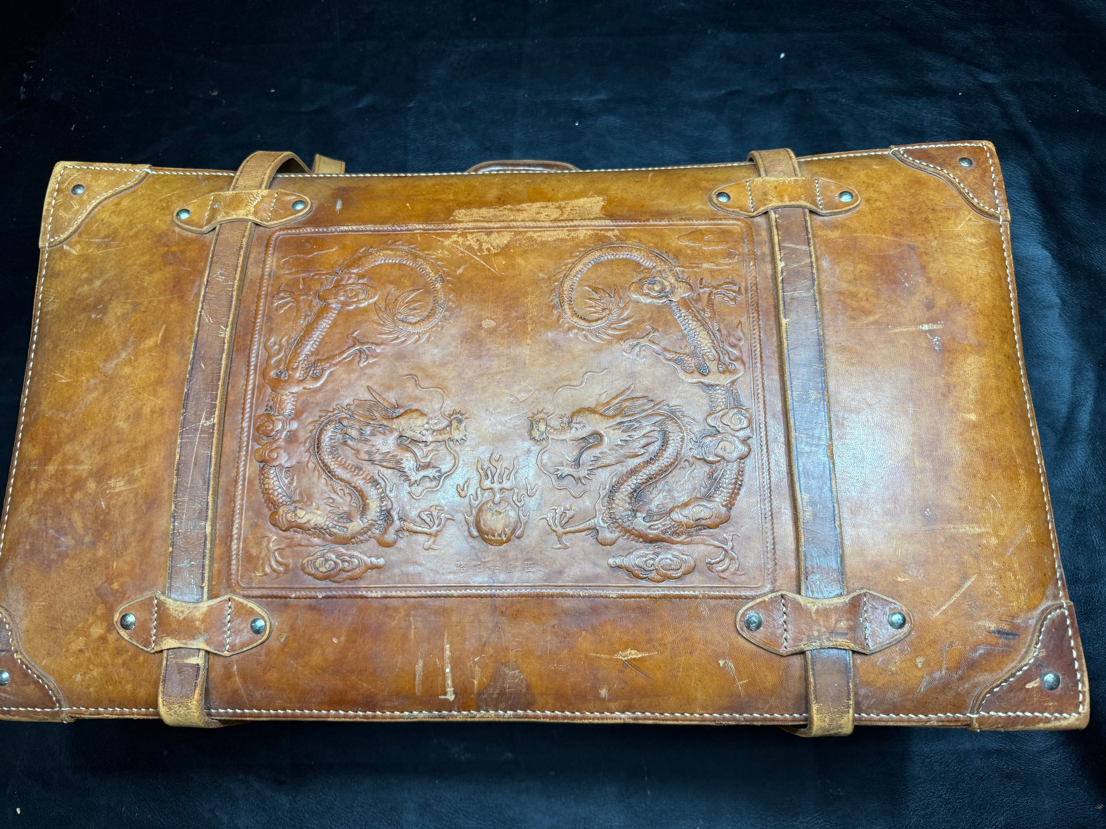 Vintage 1930s to 1940s leather suitcase with dragon motif, 25 by 15 by 9 inches